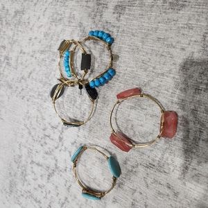 5 gold colored bangles with decorations. 3 of the 5 are new and never worn